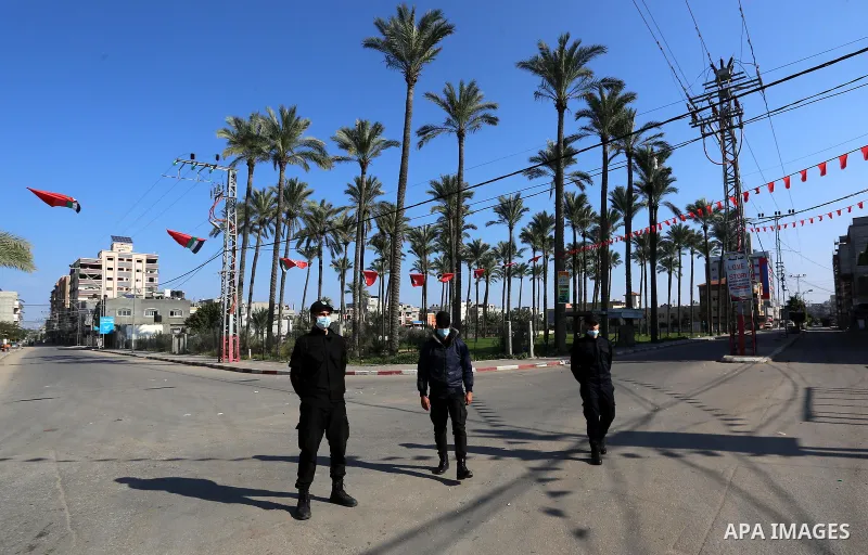 Palestinian policemen wear face masks, stand guard during a complete closure amid the spread of the Coronavirus COVID-19, in Deir al-Balah, central of Gaza Strip, on January 9, 2021, in the fifth week after the Ministry...