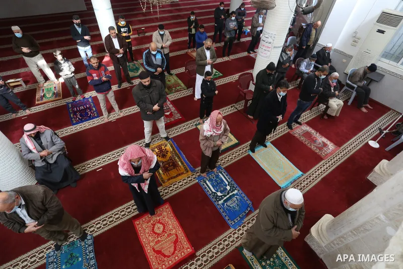Palestinian Muslim worshippers wearing face masks prayer in a mosque as the holy places reopen to worshipers to perform the weekly Islamic ritual, amid concern about the spread of the coronavirus disease (COVID-19), in D...