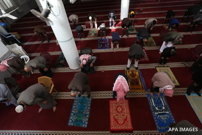 Palestinian Muslim worshippers wearing face masks prayer in a mosque as the holy places reopen to worshipers to perform the weekly Islamic ritual, amid concern about the spread of the coronavirus disease (COVID-19), in D...