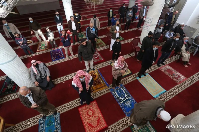 Palestinian Muslim worshippers wearing face masks prayer in a mosque as the holy places reopen to worshipers to perform the weekly Islamic ritual, amid concern about the spread of the coronavirus disease (COVID-19), in D...