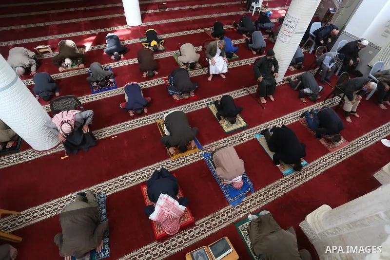Palestinian Muslim worshippers wearing face masks prayer in a mosque as the holy places reopen to worshipers to perform the weekly Islamic ritual, amid concern about the spread of the coronavirus disease (COVID-19), in D...