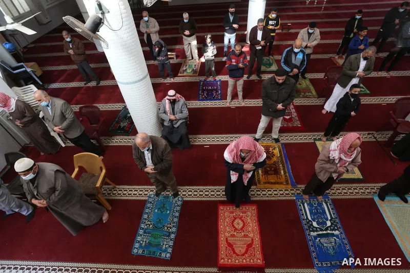 Palestinian Muslim worshippers wearing face masks prayer in a mosque as the holy places reopen to worshipers to perform the weekly Islamic ritual, amid concern about the spread of the coronavirus disease (COVID-19), in D...