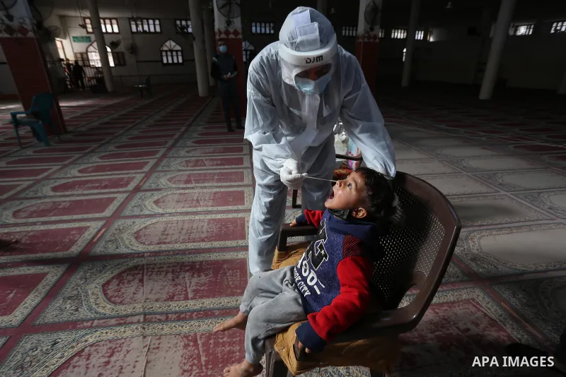 A Palestinian medical worker wearing protective gear, takes a random swab sample for COVID-19 testing inside a mosque, in Deir al-Balah, central of Gaza Strip, on January 11, 2021. The Palestinian Authority (PA) has said...