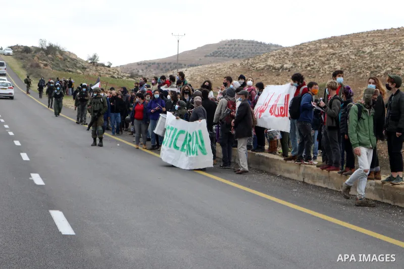 Palestinian protesters carry banners during a protest against the Israeli army and settler attacks targeting the area’s Palestinian residents, in Yatta village in the southern West bank City of Hebron on January 15, 2021...