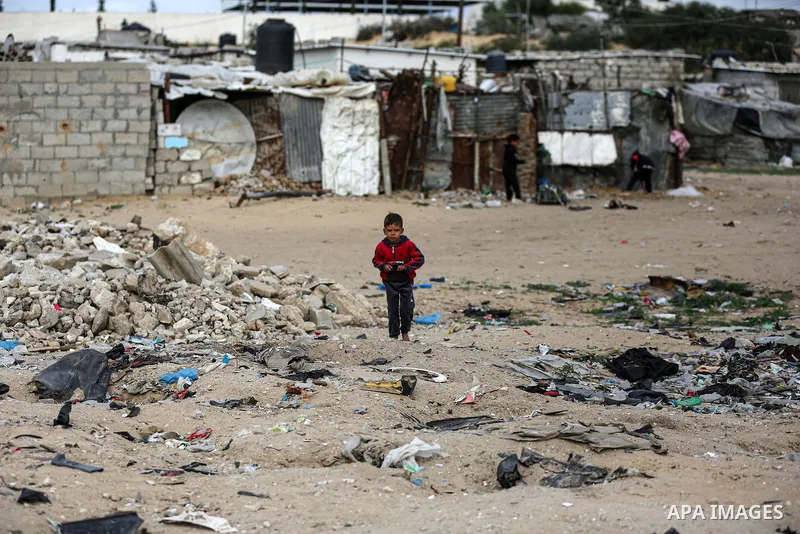 Palestinian children enjoy in front of their homes, during a rainy day at Nahr al-Bared refugee camp in Khan Younis in the southern Gaza Strip on January 18, 2021. Nahr al-Bared is a Palestinian refugee camp in southern...