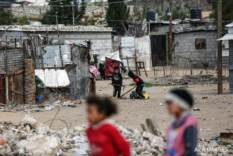 Palestinian children enjoy in front of their homes, during a rainy day at Nahr al-Bared refugee camp in Khan Younis in the southern Gaza Strip on January 18, 2021. Nahr al-Bared is a Palestinian refugee camp in southern...