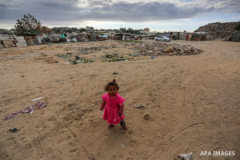 Palestinian children enjoy in front of their homes, during a rainy day at Nahr al-Bared refugee camp in Khan Younis in the southern Gaza Strip on January 18, 2021. Nahr al-Bared is a Palestinian refugee camp in southern...