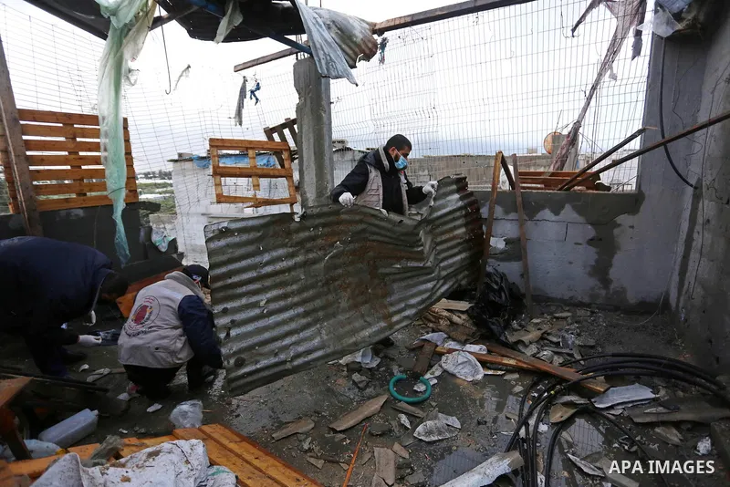 Palestinian men inspect a damaged house near the border fence with Israel, in Maghazi refugee camp in the central Gaza Strip, on January 20, 2021. Israeli tank fire struck a number of sites in the Gaza Strip, including a...