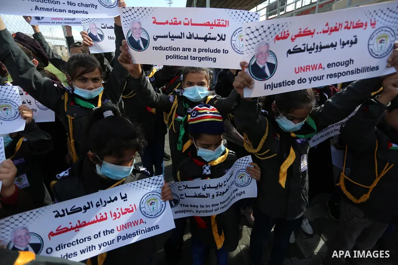 Palestinian children hold banners take part in a protest against the reduction of the food basket provided by the United Nations Relief and Works Agency for Palestine Refugees (UNRWA), in Khan Yunis in the southern Gaza...