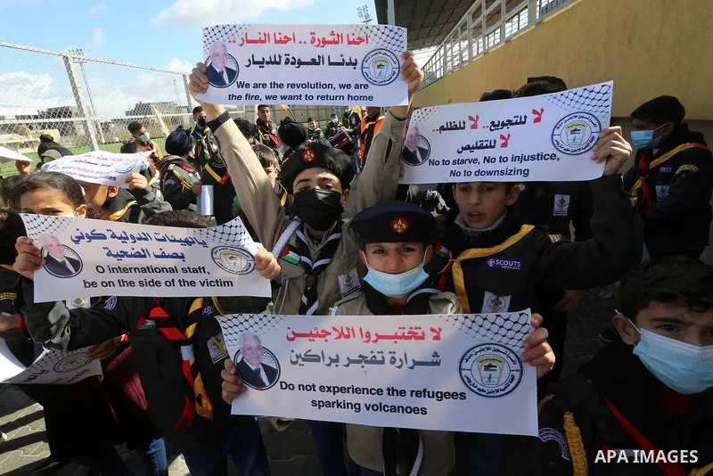 Palestinian children hold banners take part in a protest against the reduction of the food basket provided by the United Nations Relief and Works Agency for Palestine Refugees (UNRWA), in Khan Yunis in the southern Gaza...