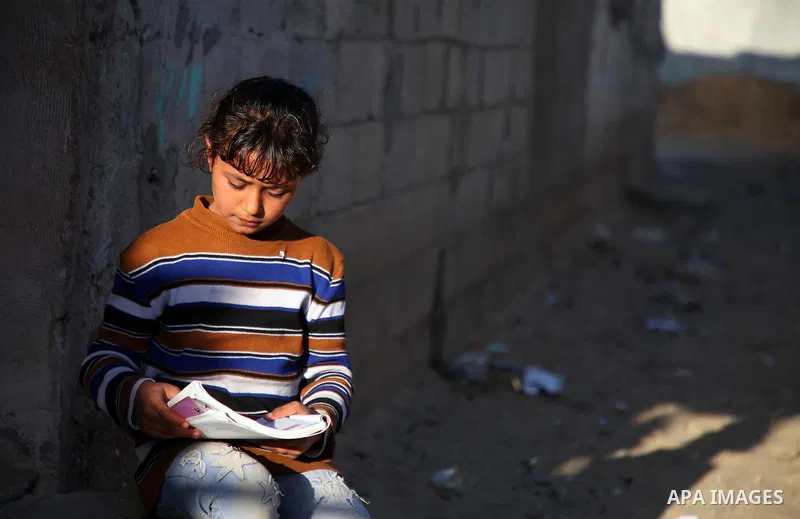 A Palestinian girl learns outside her home, in the northern of Gaza strip, on January 25, 2021. Gaza suffered shortages of water, medicine and power, a situation exacerbated by the coronavirus crisis. "19 human rights gr...