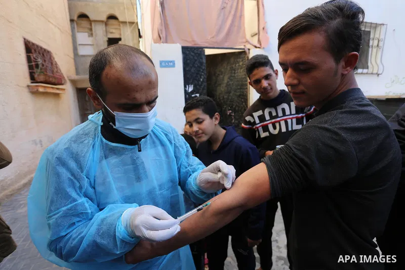A Palestinian medical worker wearing protective gear, takes a random blood sample, in Deir al-Balah, central of Gaza Strip, on January 30, 2021. Safety and infection control teams at the Ministry of Health in the Gaza St...