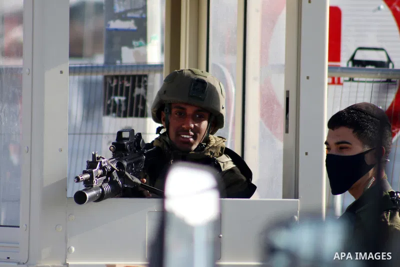 Members of Israeli security forces surround the body of a Palestinian man shot by Israeli security after reportedly attempting a knife attack, near the Israeli settlement of Gosh Etzion, north of Hebron city in the occup...