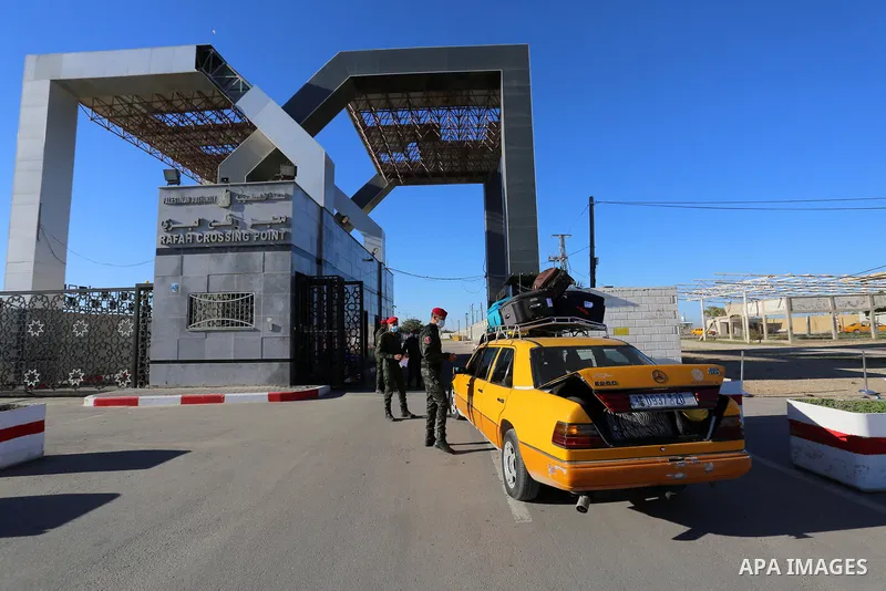 Palestinians wearing protective masks amid the COVID-19 pandemic, as they wait for travel permits to cross into Egypt through the Rafah border crossing, in Rafah in the southern of Gaza Strip, on February 1, 2021, after...