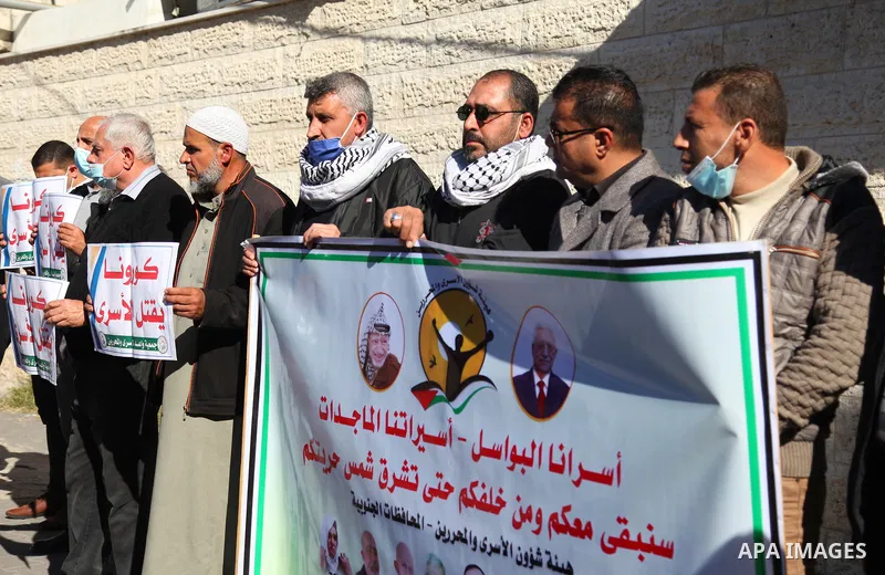 Palestinians take part in a protest to show solidarity with prisoners and the spread of the coronavirus disease (COVID-19) on Israeli Jails, in front of the headquarters of Red cross in Gaza city on February 01, 2021. At...