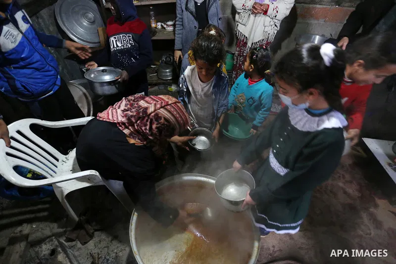 Palestinian volunteer cook Amal Abu Amra, 41, prepares free meals of green pea stew from donors, to help needy families in an impoverished neighbourhood in Gaza City, on February 4, 2021. Amra cooks the meals with money...