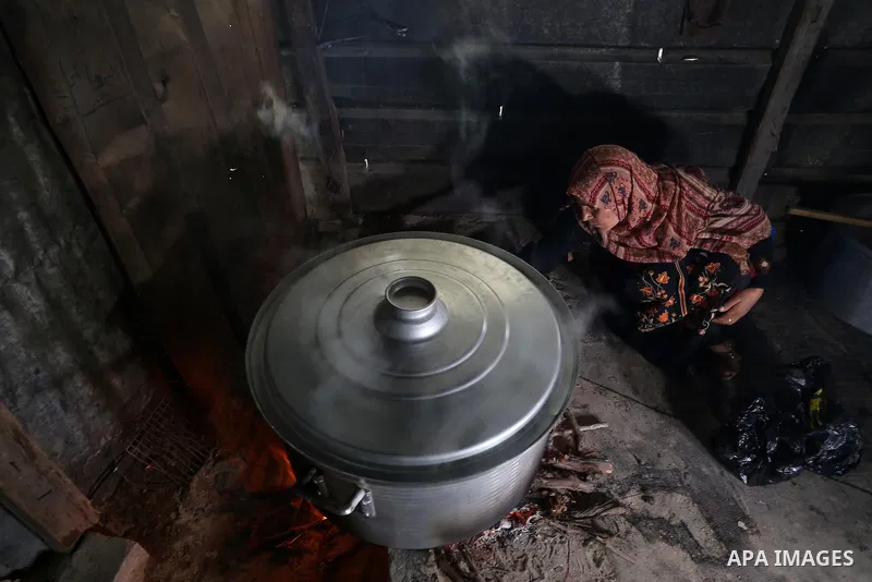 Palestinian volunteer cook Amal Abu Amra, 41, prepares free meals of green pea stew from donors, to help needy families in an impoverished neighbourhood in Gaza City, on February 4, 2021. Amra cooks the meals with money...