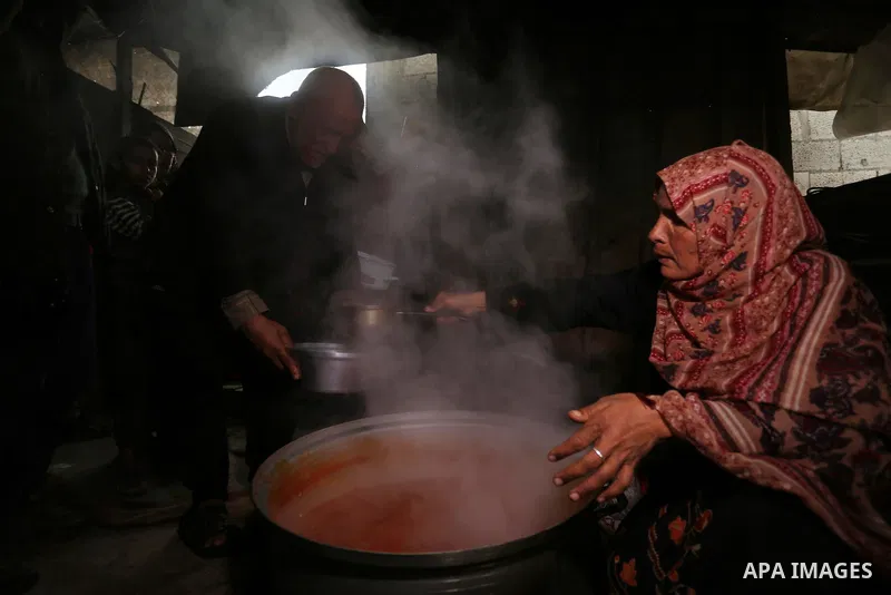 Palestinian volunteer cook Amal Abu Amra, 41, prepares free meals of green pea stew from donors, to help needy families in an impoverished neighbourhood in Gaza City, on February 4, 2021. Amra cooks the meals with money...