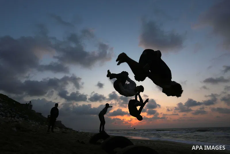Palestinian youths demonstrate their parkour skills on the beach, amid the outbreak of the coronavirus disease (COVID-19), in Deir Al-Balah in the center of the Gaza Strip on February 5, 2021. Photo by Ashraf Amra