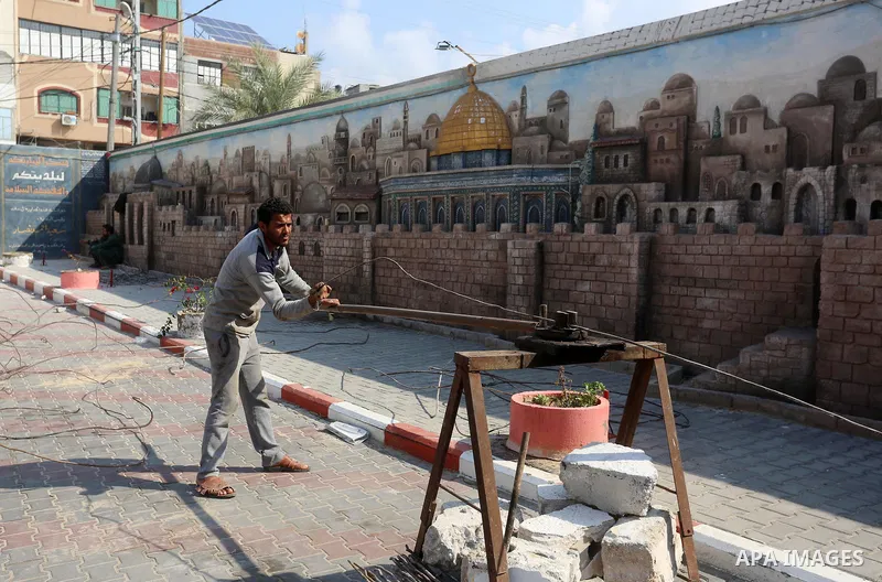 Palestinian workers demolish the old municipality building of Deir Al-Balah to develop the place in Deir Al-Balah in the central Gaza Strip, on February 6, 2021. Gaza suffered shortages of water, medicine and power, a si...