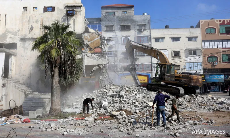 Palestinian workers demolish the old municipality building of Deir Al-Balah to develop the place in Deir Al-Balah in the central Gaza Strip, on February 6, 2021. Gaza suffered shortages of water, medicine and power, a si...