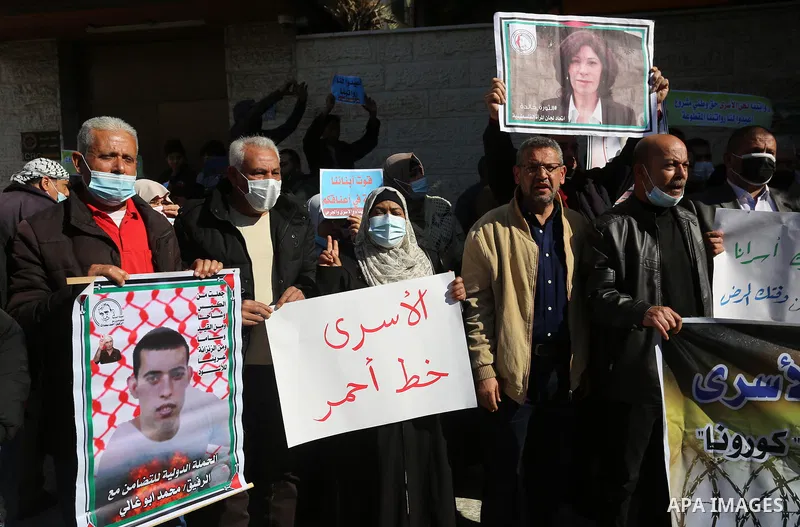 Palestinians take part in a protest to show solidarity with prisoners and the spread of the coronavirus disease (COVID-19) on Israeli Jails, in front of the headquarters of Red cross in Gaza city, on February 08, 2021. T...
