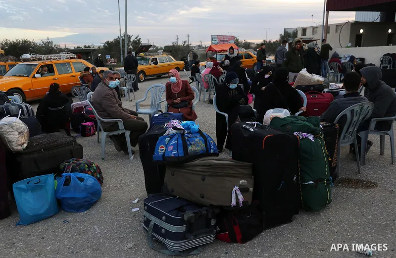 Palestinians wearing protective masks amid the COVID-19 pandemic, as they wait for travel permits to cross into Egypt through the Rafah border crossing, in Rafah in the southern of Gaza Strip, on February 9, 2021. The Ra...
