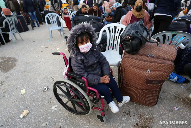 Palestinians wearing protective masks amid the COVID-19 pandemic, as they wait for travel permits to cross into Egypt through the Rafah border crossing, in Rafah in the southern of Gaza Strip, on February 9, 2021. The Ra...