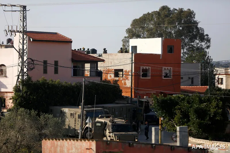 Israeli soldiers are seen atop the house of Palestinian Mohammed Kabaha, who was allegedly accused by the Israeli occupation of killing an Israeli settler in late December 2020, as they prepare to blow it up, in the West...
