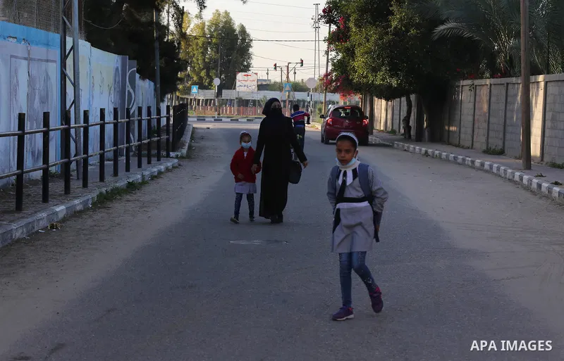 Palestinian students wearing protective face masks, as schools gradually reopen amid the coronavirus disease (COVID-19) outbreak, at their school run by the United Nations Relief and Works Agency (UNRWA) in Deir al-Balah...