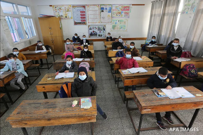 Palestinian students wearing protective face masks, as schools gradually reopen amid the coronavirus disease (COVID-19) outbreak, at their school run by the United Nations Relief and Works Agency (UNRWA) in Deir al-Balah...