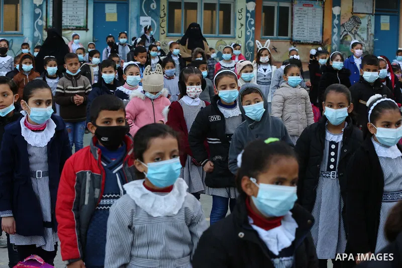 Palestinian students wearing protective face masks, as schools gradually reopen amid the coronavirus disease (COVID-19) outbreak, at their school run by the United Nations Relief and Works Agency (UNRWA) in Deir al-Balah...