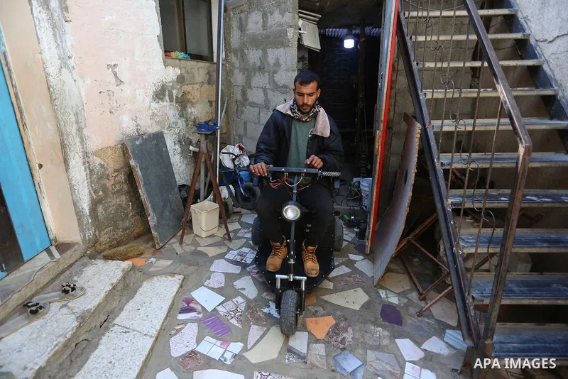 Palestinian technician Moamen Abu Raida,29, tries to assemble a small electric vehicle at his home workshop in Bani Suhaila, a town east of Khan Yunis in the southern of the Gaza Strip, on February 15, 2021. Using scrap...