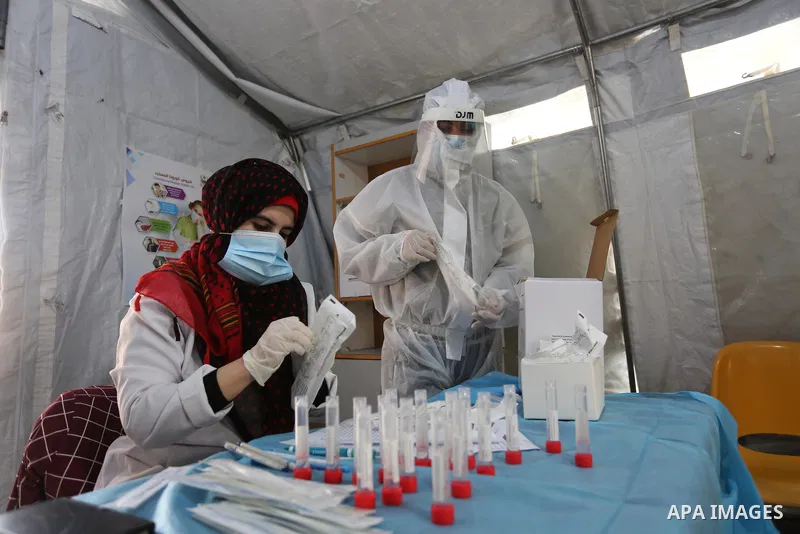 A Palestinian health worker collects a swab sample from a person for Covid-19 test in Khan Younis in the southern Gaza Strip, on February 16, 2021. The Palestinian Authority accused Israel of refusing to allow some 2,000...