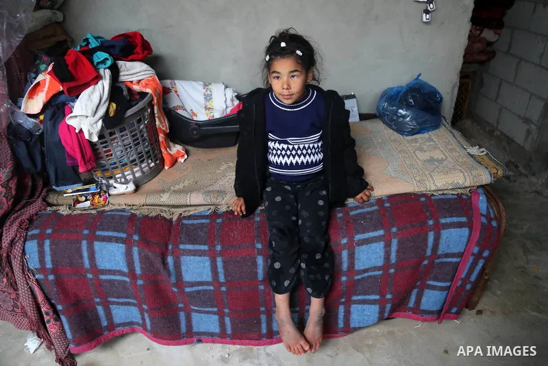 Palestinians stand in their house after it was flooded by rain water during a rainy day, in al-Shati refugee camp in Gaza City on February 17, 2021. The cloudy, stormy and very cold conditions are expected to continue on...