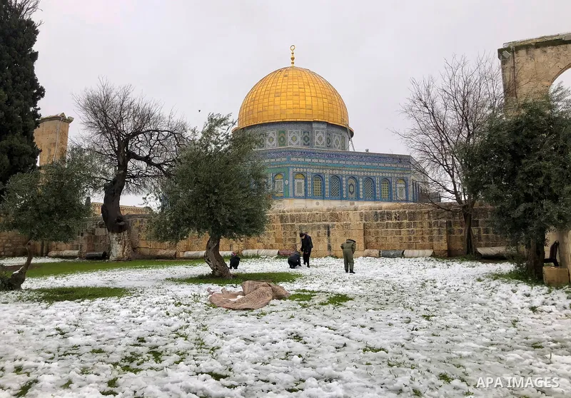 Palestinians enjoy during a snow storm, in the Dome of the Rock Mosque in Jerusalem's al-Aqsa mosque compound, on February 18, 2021. The bad weather and snow that hit Palestine yesterday and is expected to continue today...