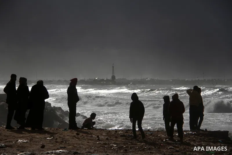Palestians enjoy during a rainy day, at a beach in Gaza City, on February 18, 2021. The bad weather and snow that hit Palestine yesterday and is expected to continue today caused damage to homes, mainly in the Gaza Strip...