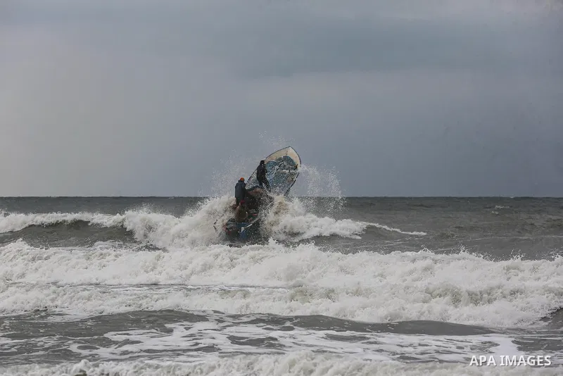 Palestinian fishermen work on their fishing boats in Deir al-Balah, in the central of Gaza Strip, on February 19, 2021. The bad weather and snow that hit Palestine yesterday led to the disruption of fishermen's work at s...