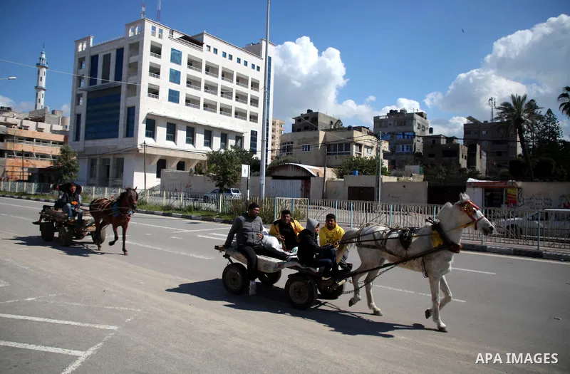 Palestinians ride a donkey car, in Gaza City, on February 20 2021. Weather today in Gaza strip, Palestine is going to be Partly cloudy with a maximum temperature of 16°c and minimum temperature of 1°c. Photo by Mahmoud A...