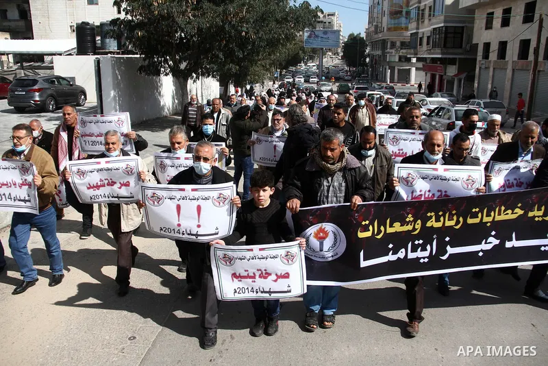Families of Palestinian martyrs and wounded, take part in a protest against the Palestinian Authority's decision to cut their salaries for seven years, in Gaza city, on February 21, 2021. In January 2019, the PA cut the...
