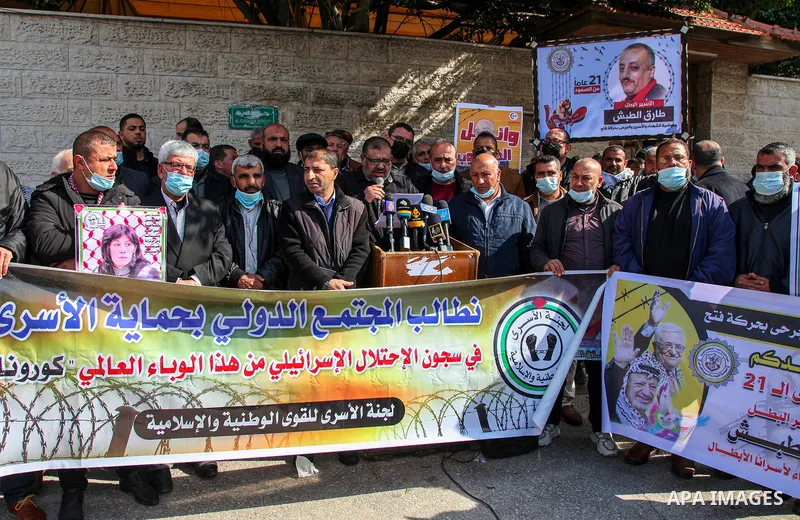 Palestinians take part in a protest to show solidarity with prisoners and the spread of the coronavirus disease (COVID-19) on Israeli Jails, in front of the headquarters of Red cross in Gaza city, on February 22, 2021. P...