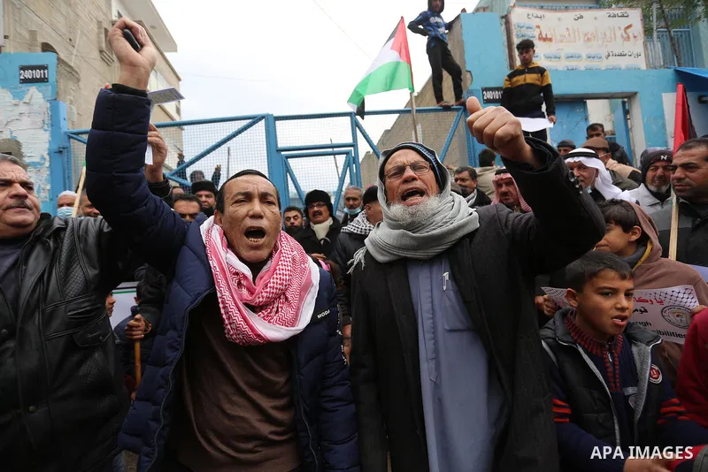 Palestinians take part in a protest against the reduction of the food basket provided by UNRWA, in front of the its aid distribution center, in Khan Yunis, in the southern Gaza Strip, on February 23, 2021. Palestinian re...