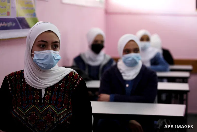Palestinian students wearing protective face masks, sit in a classroom, in the morning of the first day of the second semester study, amid the coronavirus disease (COVID-19) outbreak, at their school, in Gaza city, on Fe...
