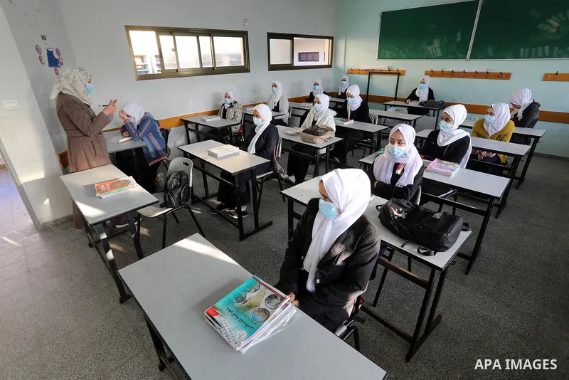 Palestinian students wearing protective face masks, sit in a classroom, in the morning of the first day of the second semester study, amid the coronavirus disease (COVID-19) outbreak, at their school, in Dair Al Balah in...