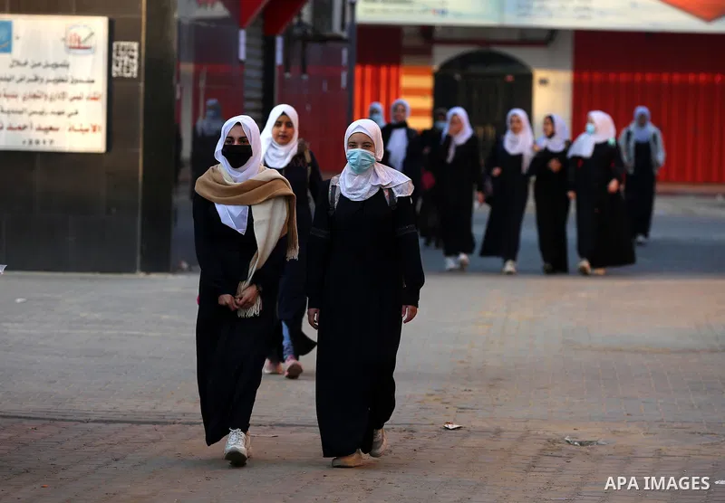 Palestinian students wearing protective face masks, return back to their school, in the morning of the first day of the second semester study, amid the coronavirus disease (COVID-19) outbreak, in Dair Al Balah in the cen...