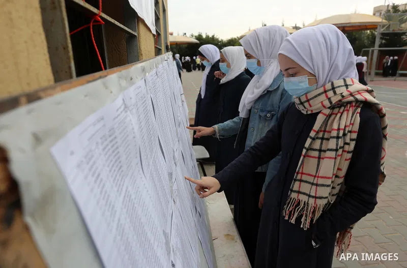 Palestinians look the Primary voter register, at school in Deir El-Balah, in the center of the Gaza Strip, on March 01, 2021. More than 93 percent of eligible Palestinian voters registered to take part in the scheduled P...