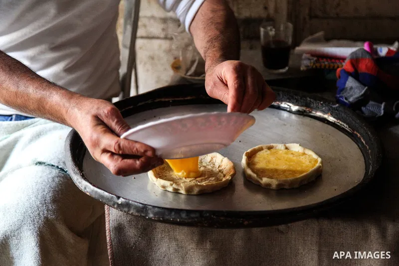 Palestinian Ismail Qassem "Abu Zuhair" prepares pastries to sell to his customers at the gold market in Gaza City on March 4, 2021. The Qassem family members prepare and sell food consisting of pizza pills, thyme, eggs,...