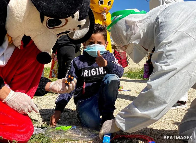 Palestinian doctors take part in the campaign, to help children infected with Coronavirus, in Dura village southwest of Hebron city in the occupied West Bank, on March 6, 2021. Photo by Ihab Allami