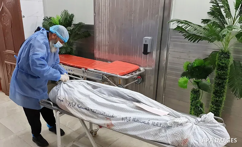 People stand around the body of fisherman was killed in an explosion of unknown cause off the coast of the Gaza Strip, at Nasser Hospital in Khan Yunis, southern Gaza Strip, on March 7, 2021. Three Palestinian fishermen...