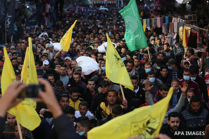 Palestinian mourners carry the body of the three Palestinian fishermen, who were killed when their boat exploded off Gaza's coast in the Mediterranean Sea, during their funeral in Khan Yunis in the southern Gaza Strip on...